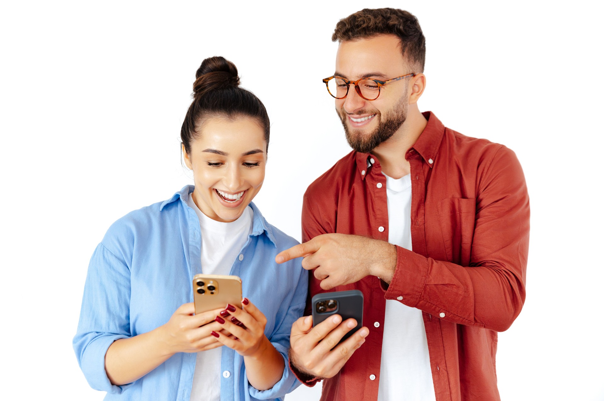 Happy man and woman looking at smartphones together, sharing joyful moments of connection, dressed casually, reflecting modern communication and technology, standing on an isolated white background